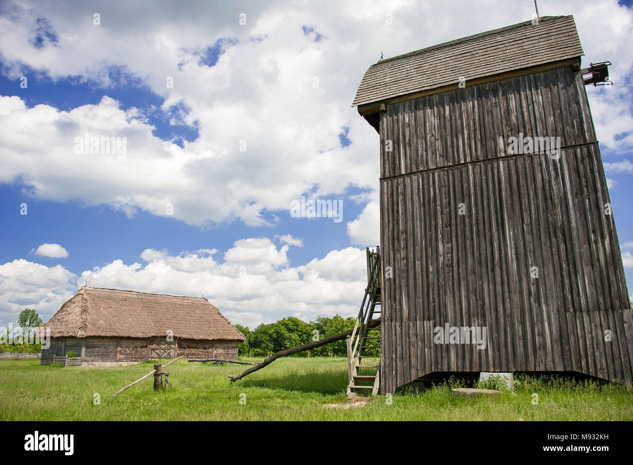 Musée du Village de Mazovie Sierpc. Une reconstruction de village dans la campagne polonaise avec la ferme, un vieux moulin et bleu, ciel nuageux Banque D'Images
