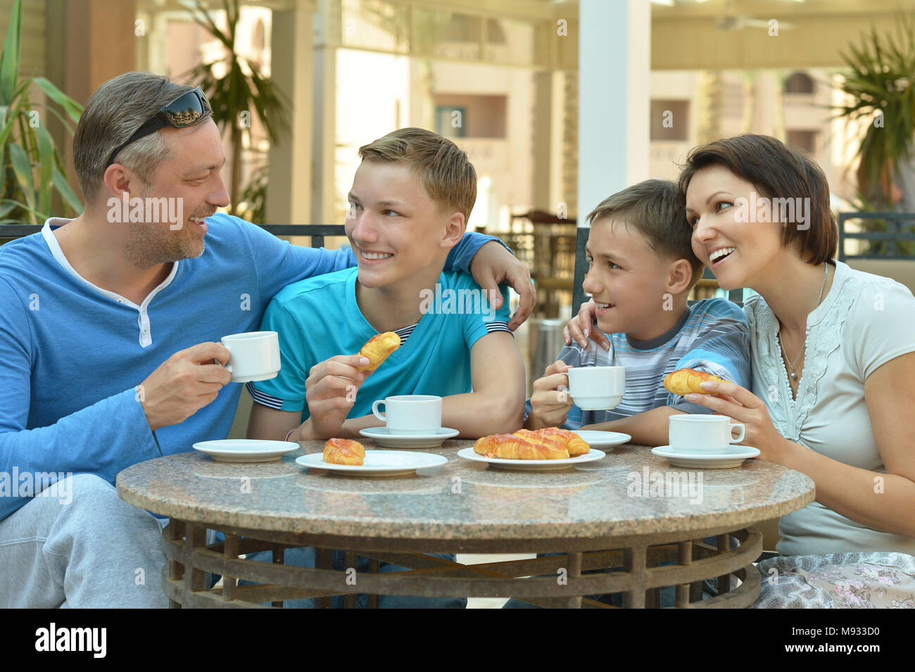 Famille heureuse de prendre le petit déjeuner ensemble dans le café en ...