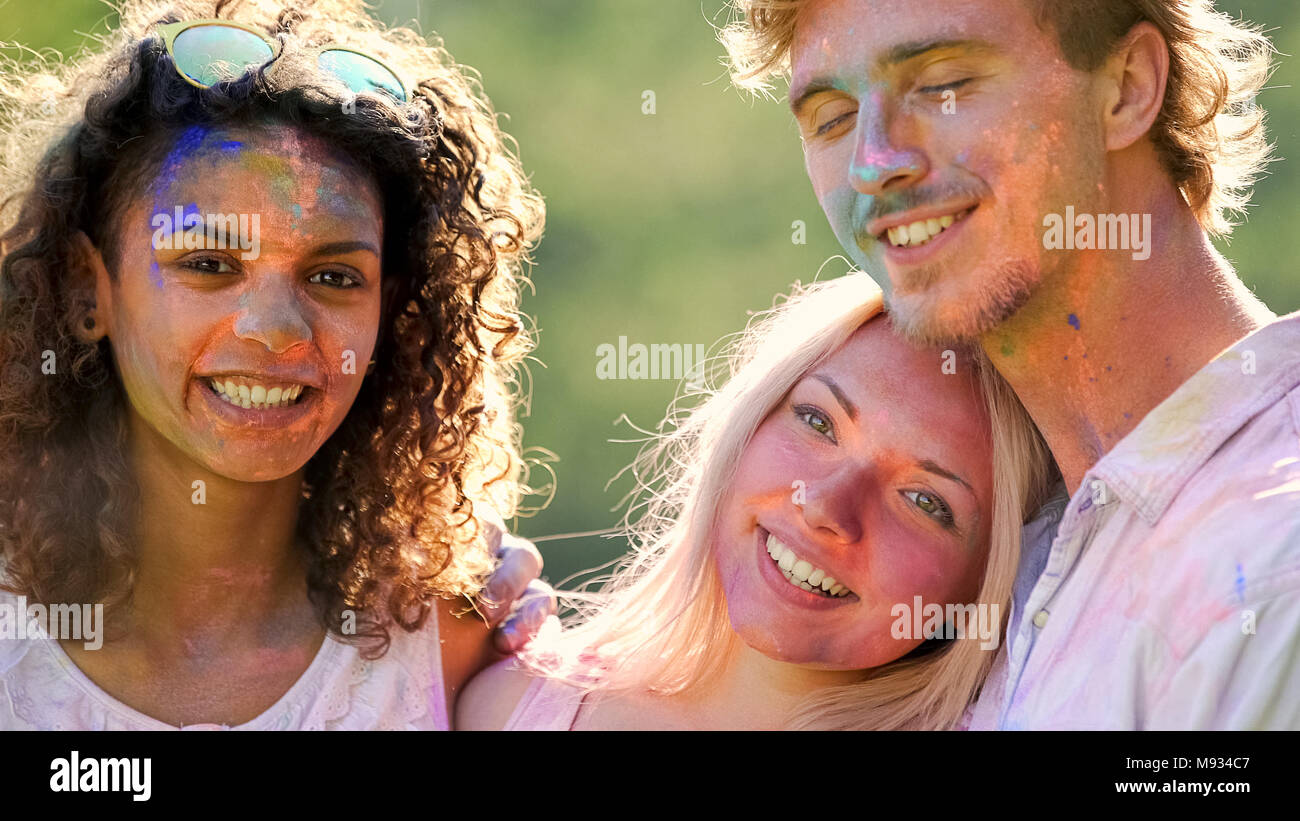 Les émotions positives des professionnels hommes et femmes friends hugging at festival couleur Banque D'Images
