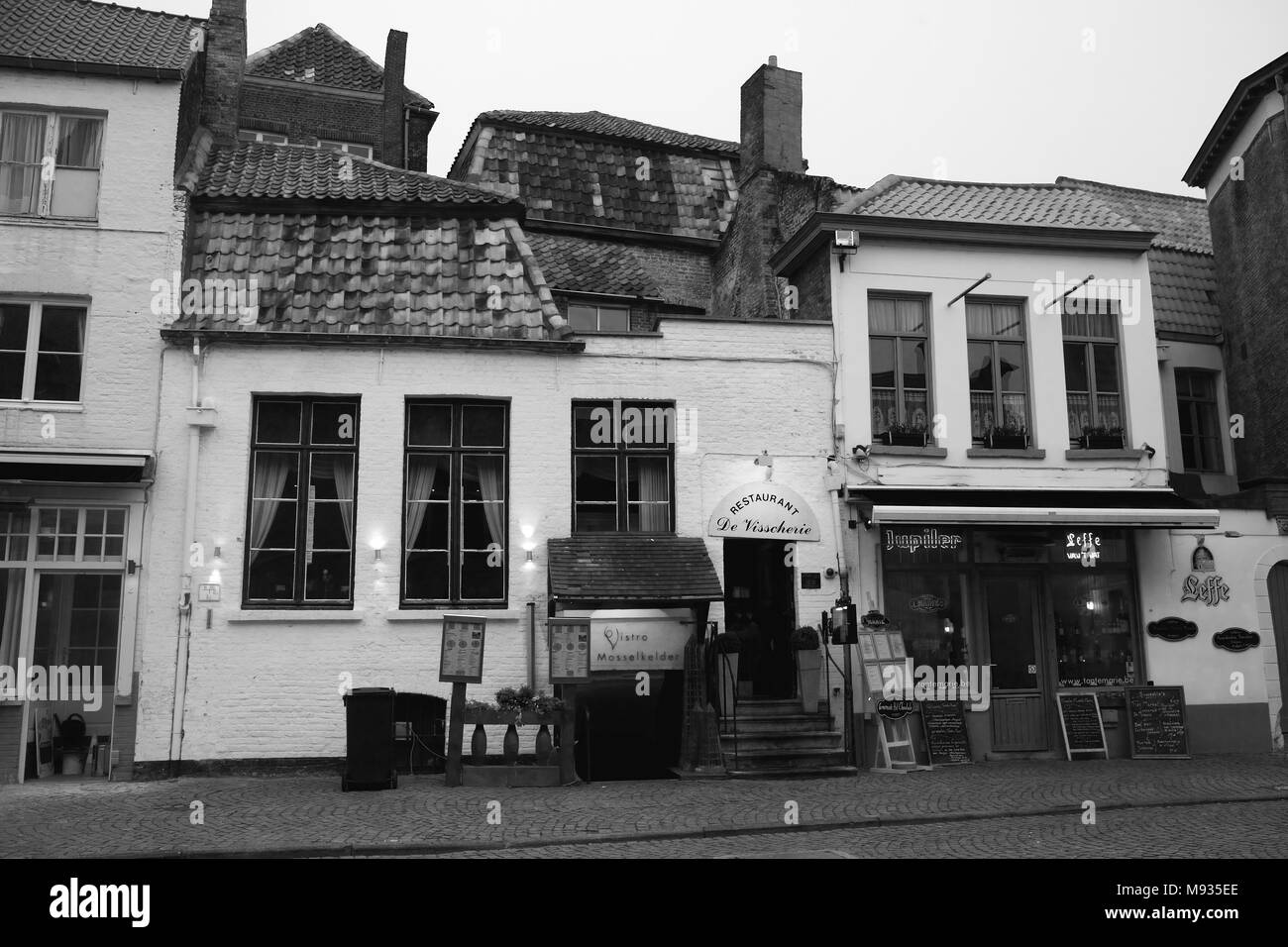Huidenvettersplein, Brugge, Belgique: Le Restaurant de Visscherie et le café Tante Marie dans la petite place magique. Version noir et blanc Banque D'Images