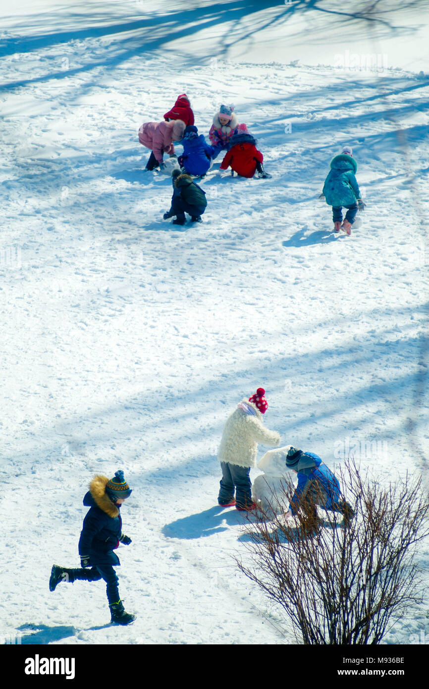 Groupe d'enfants jouant sur la neige en hiver, solidarité, vacances, kid Banque D'Images