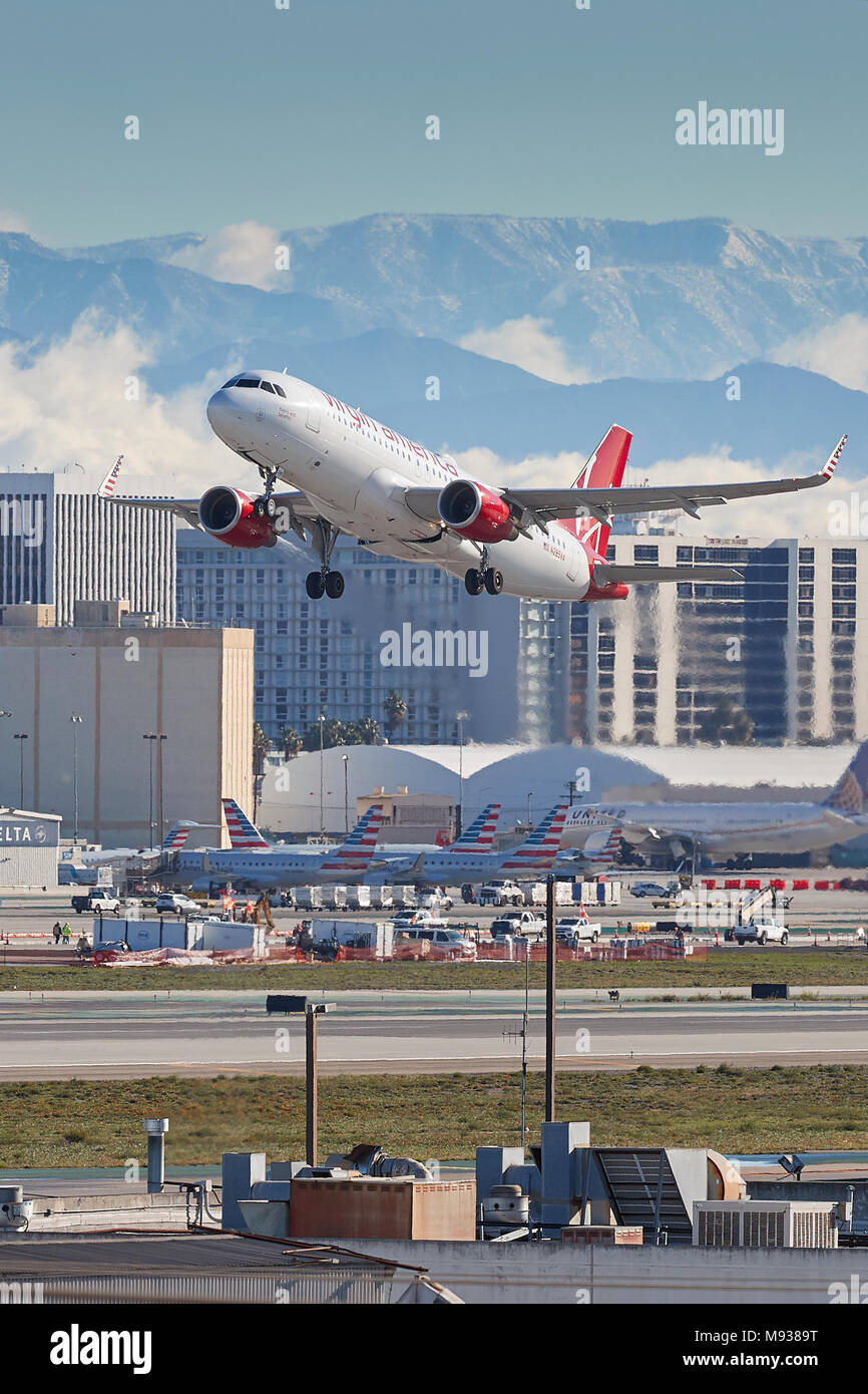 Virgin America Airbus A320, avion à réaction au décollage de l'Aéroport International de Los Angeles, LAX, les montagnes San Gabriel derrière. Banque D'Images