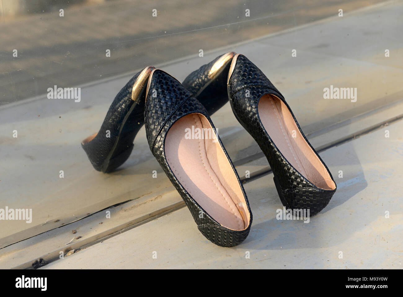 Une paire de souliers pour sèche au soleil contre une fenêtre réfléchissante dans district de Dongcheng, Beijing, Chine Banque D'Images