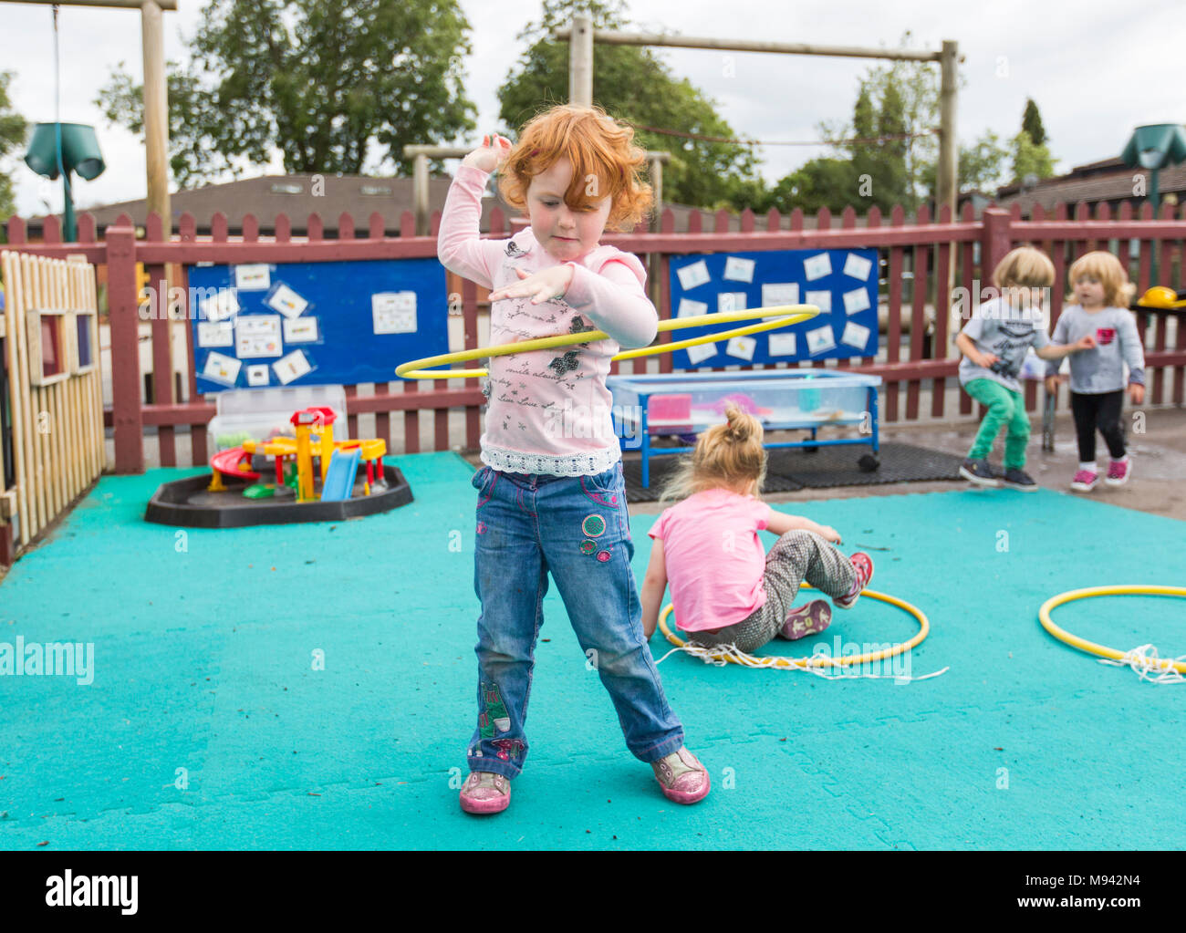 L'école maternelle des enfants jouent dans une aire de jeux dans le Warwickshire, Royaume-Uni Banque D'Images