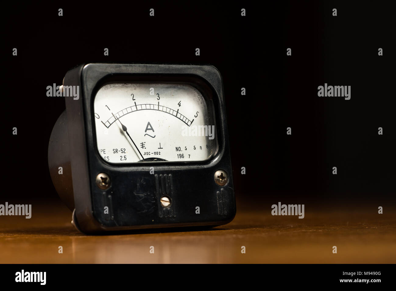 Libre d'un ancien ampèremètre analogique noir sur une table en bois Banque D'Images