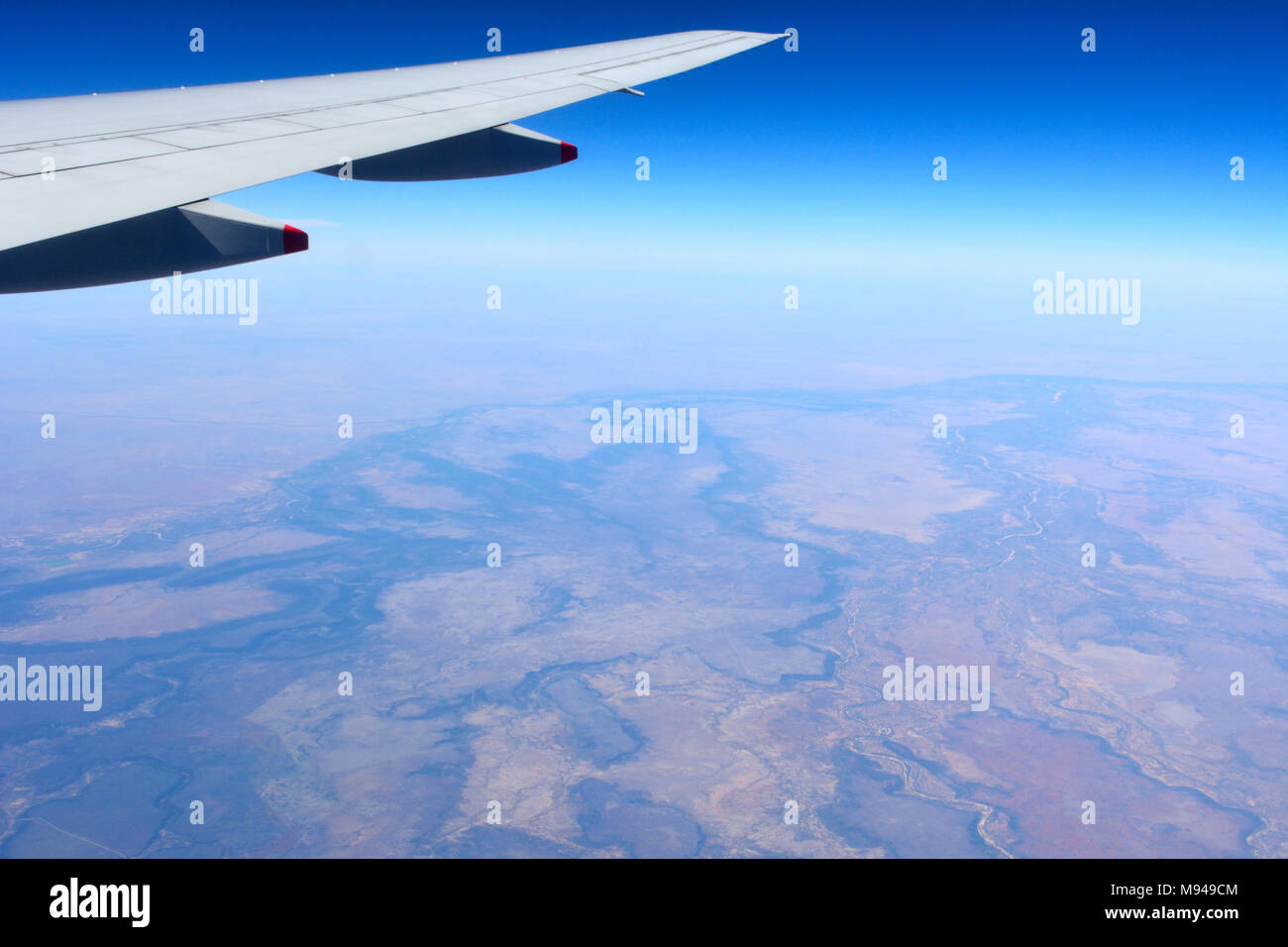 Aile d'avion volant au-dessus de paysage désertique dans l'outback australien. Banque D'Images