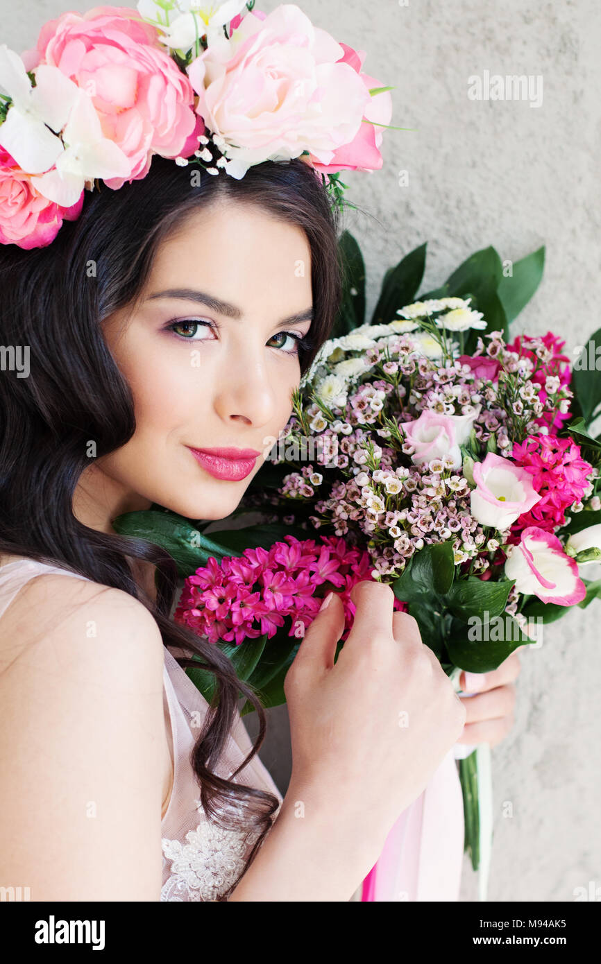 Cute Model femme avec le maquillage, les cheveux ondulés et de fleurs Banque D'Images