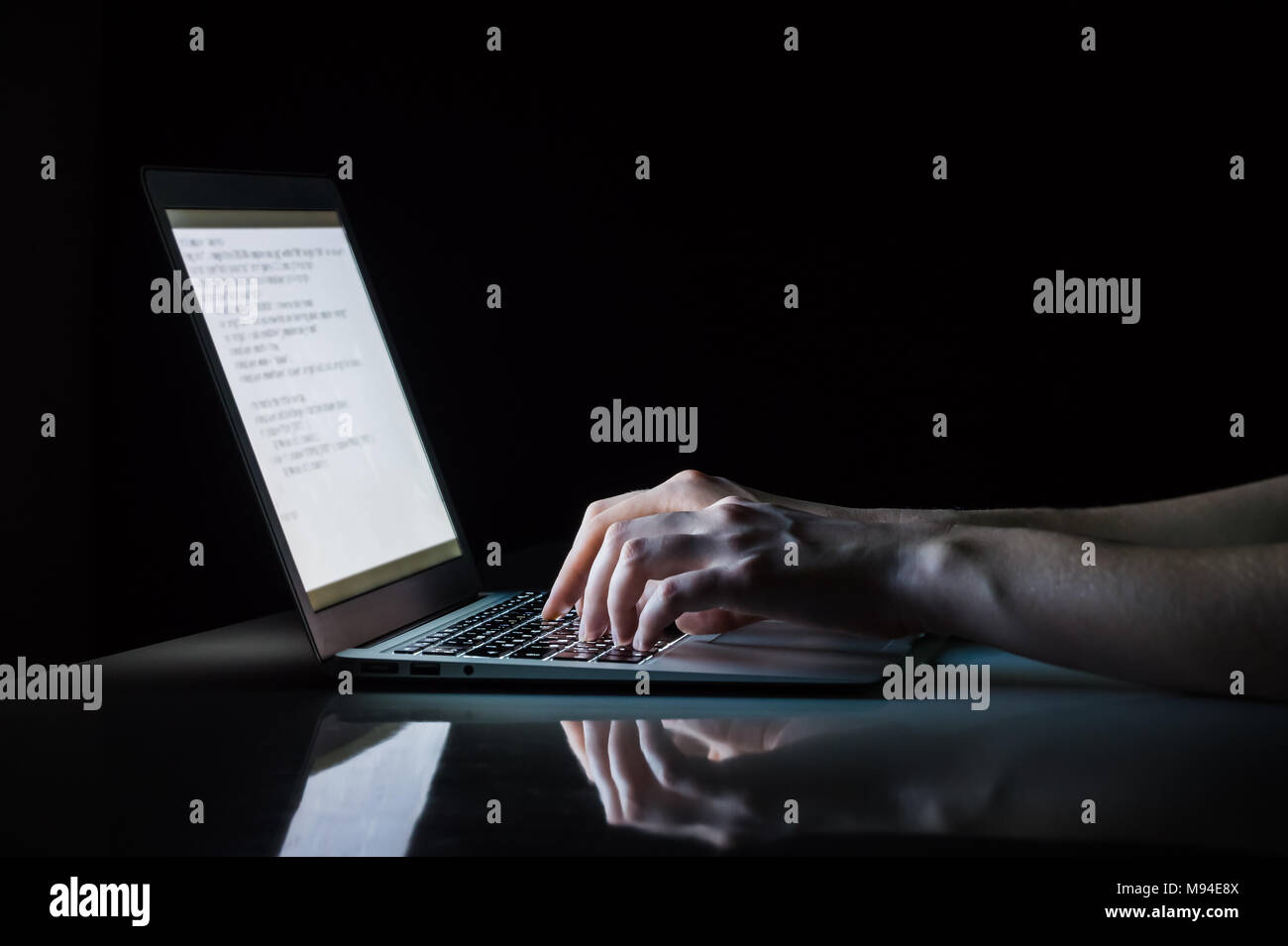 Travailler à un ordinateur portable dans la nuit. Close up image des femmes mains saisissez du texte ou code de programmation à l'ordinateur dans la lumière ambiante naturelle à la fin de soir Banque D'Images