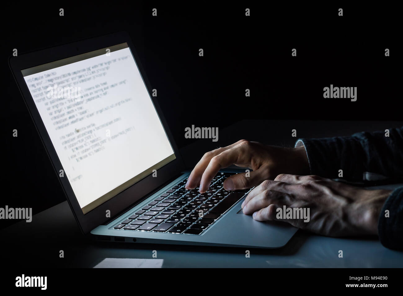 Travailler à un ordinateur portable dans la nuit. Image Gros plan homme asiatique de la saisie de texte ou code de programmation en informatique dans la lumière ambiante naturelle à la fin de soir Banque D'Images