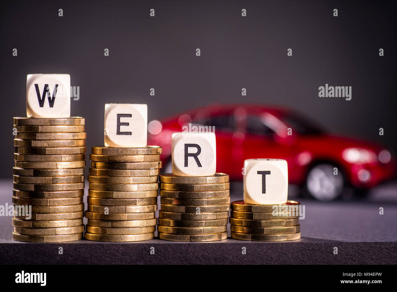 Pile de pièces et le mot valeur avec une voiture rouge à l'arrière-plan Banque D'Images