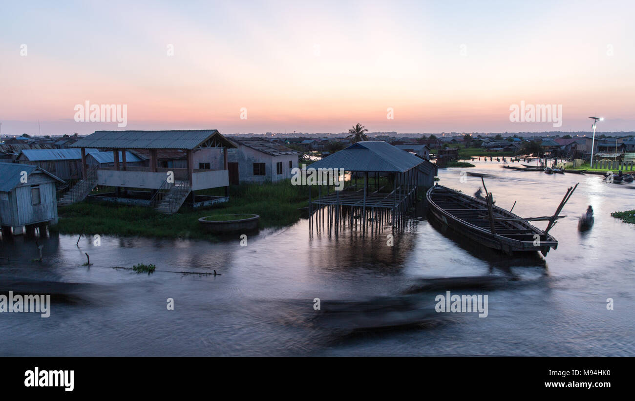 L'heure de pointe sur le Lac Nokoué. Les résidents de Ganvie rush accueil alors que le soleil se couche sur le plus grand village sur pilotis en Afrique. Banque D'Images