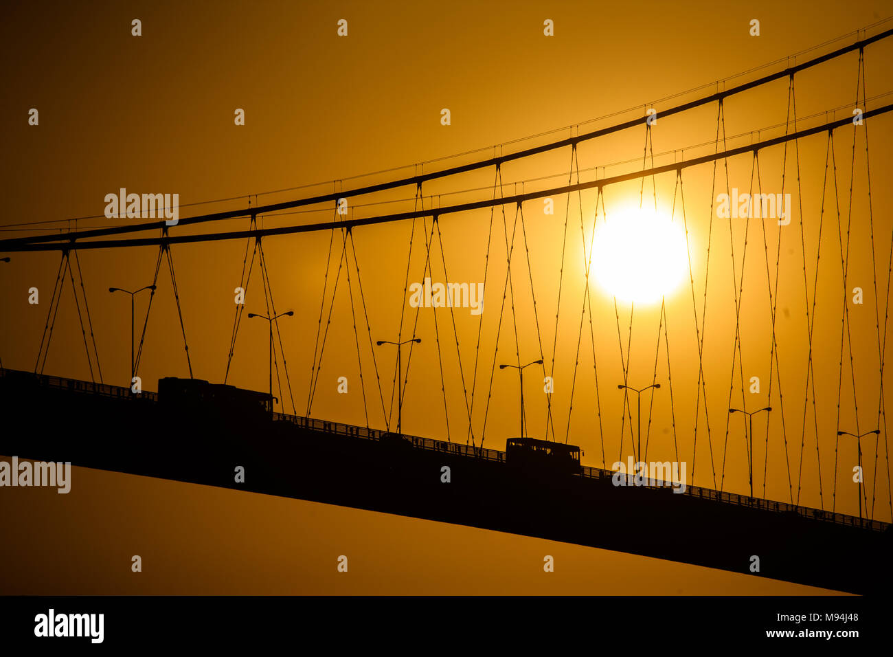 Or un soleil se couche derrière les câbles du pont du Bosphore, Istanbul, Turquie Banque D'Images