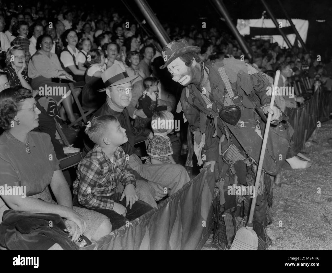 Un clown fonctionne de la foule lors d'une performance de cirque en Géorgie, ca. 1948. Banque D'Images