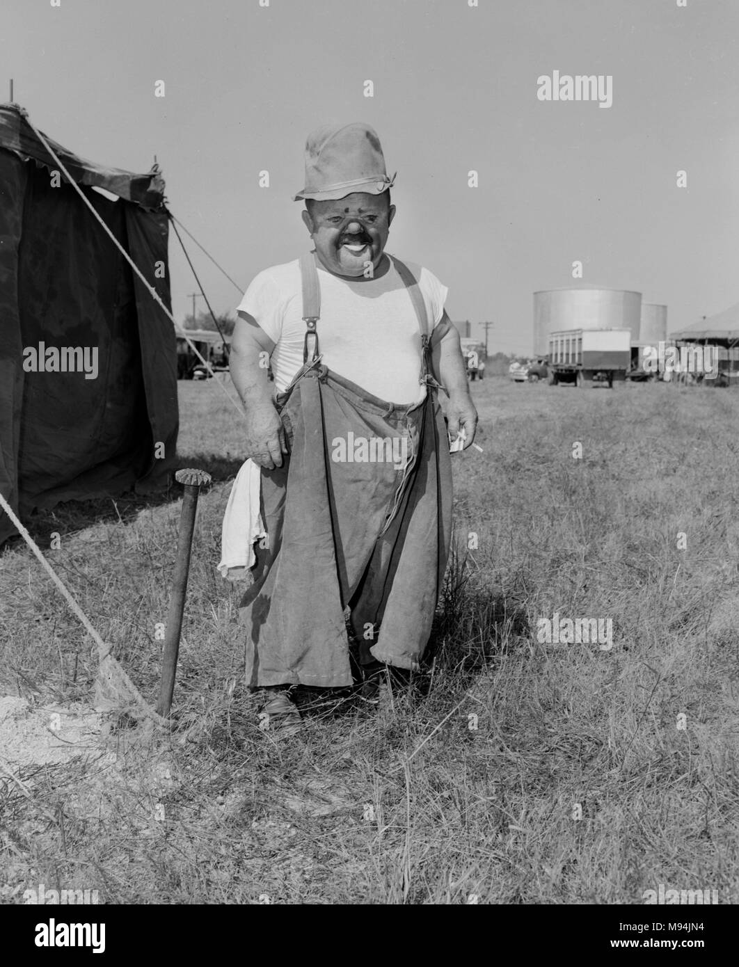 Un clown avec l'Christiani Brothers Circus prend une pause-cigarette backstage en Géorgie, ca. 1955. Banque D'Images