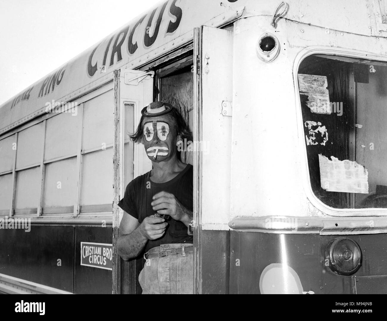 Un clown avec l'Christiani Brothers Circus prend une pause-cigarette backstage en Géorgie, ca. 1955. Banque D'Images