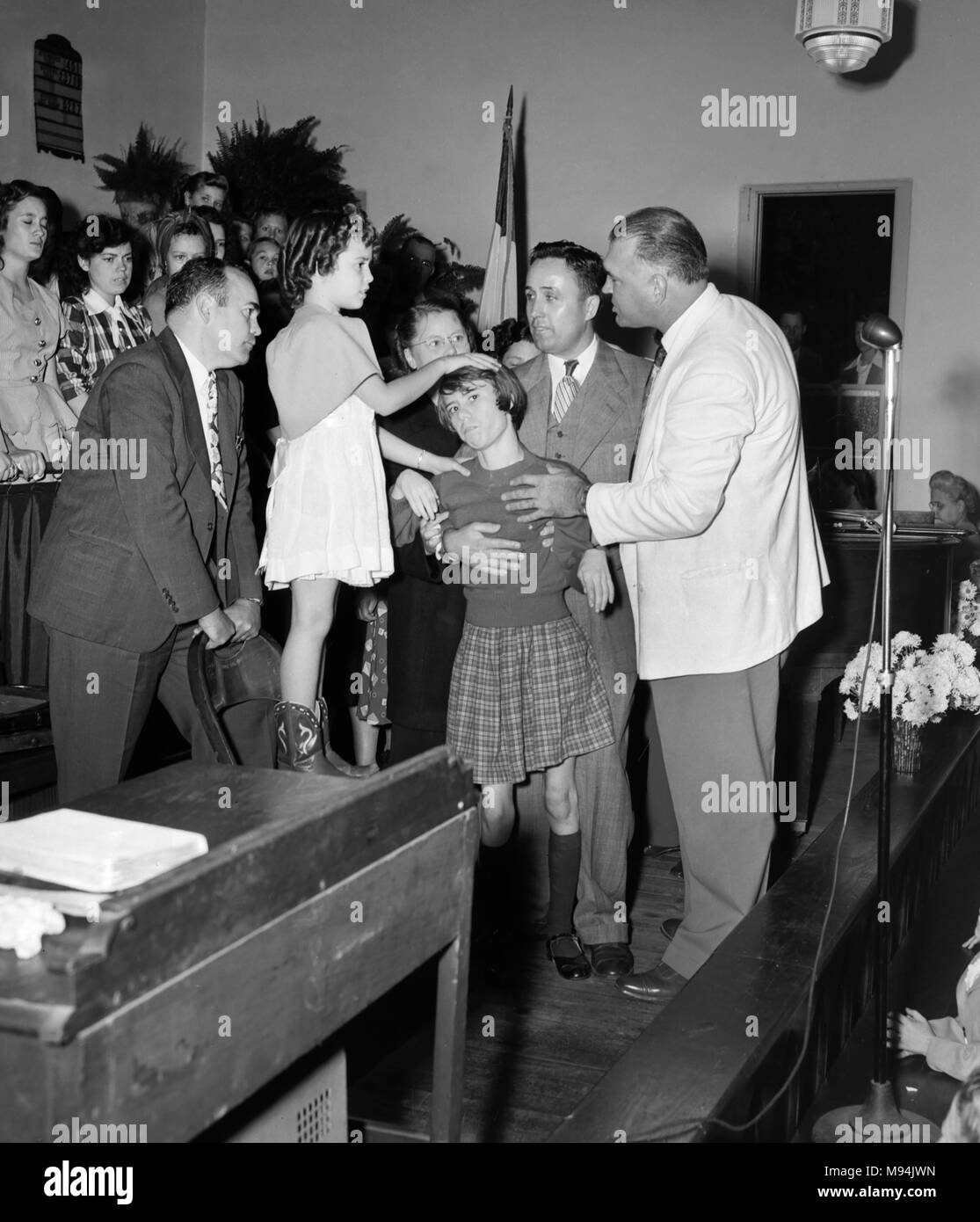 Une jeune fille utilise l'imposition des mains pour guérir une adolescente handicapée physique en Géorgie, ca. 1950. Banque D'Images