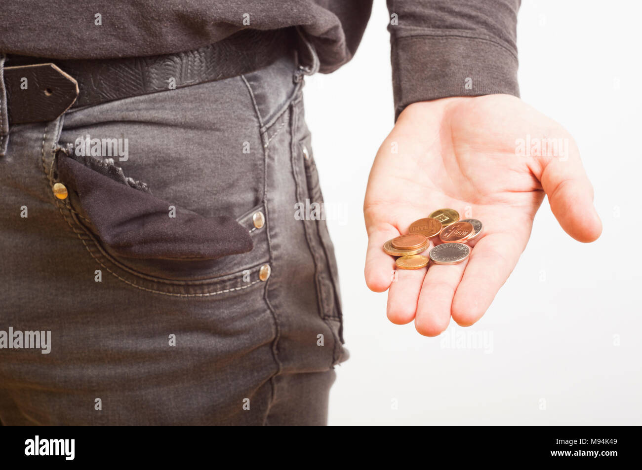 Pauvre homme main tenant les pièces de monnaie et poche vide Banque D'Images