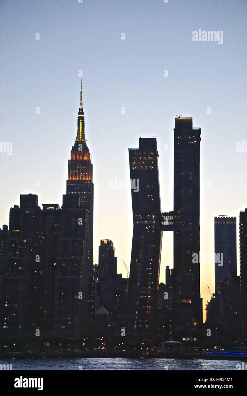 New York, NY, USA : Silhouettes de l'Empire State Building (1931) et l'Américain Bâtiments en cuivre (2017) sur une claire nuit d'été à Manhattan. Banque D'Images