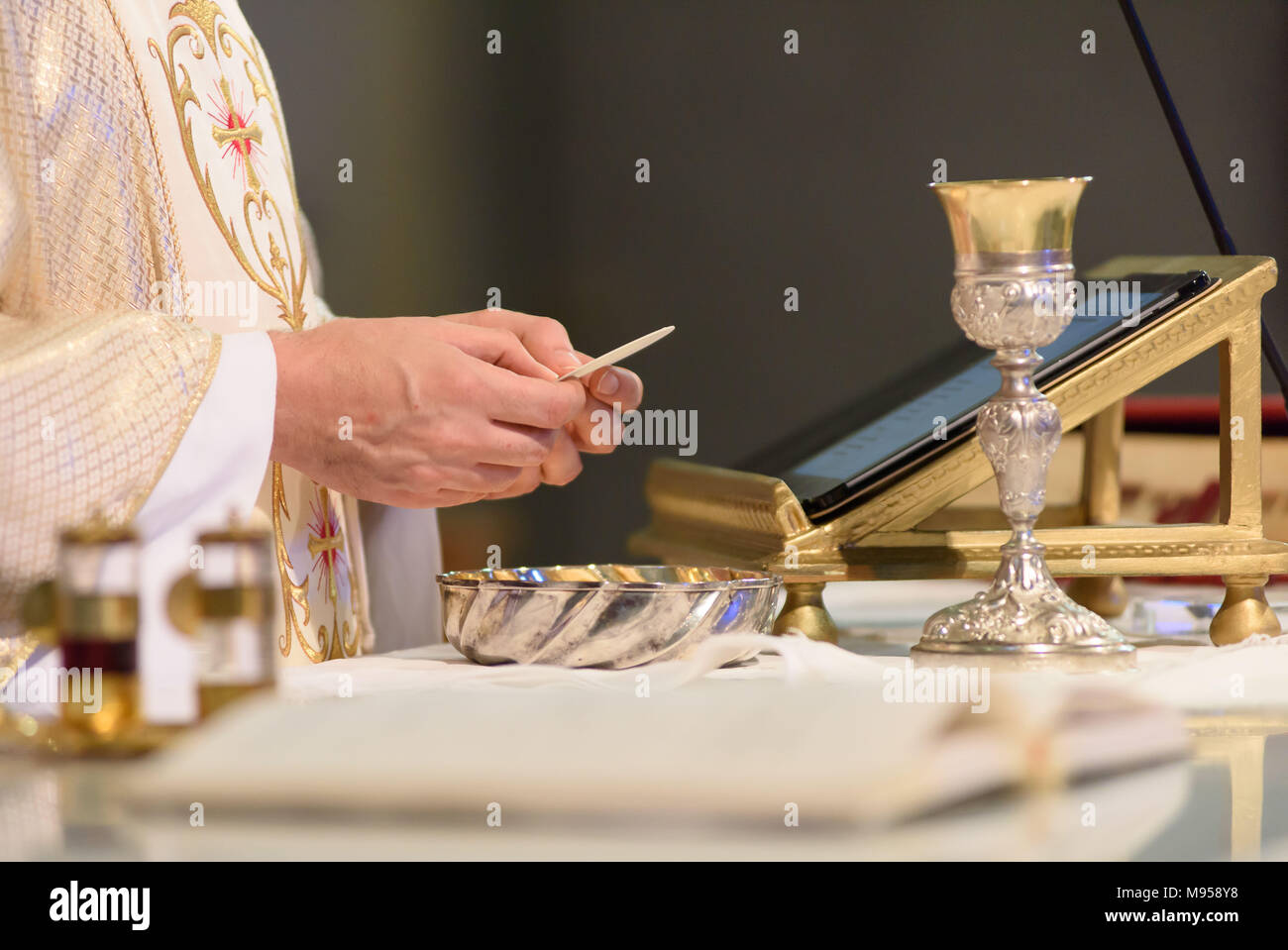 Au cours de la messe chrétienne un prêtre célèbre le rite de la communion Banque D'Images