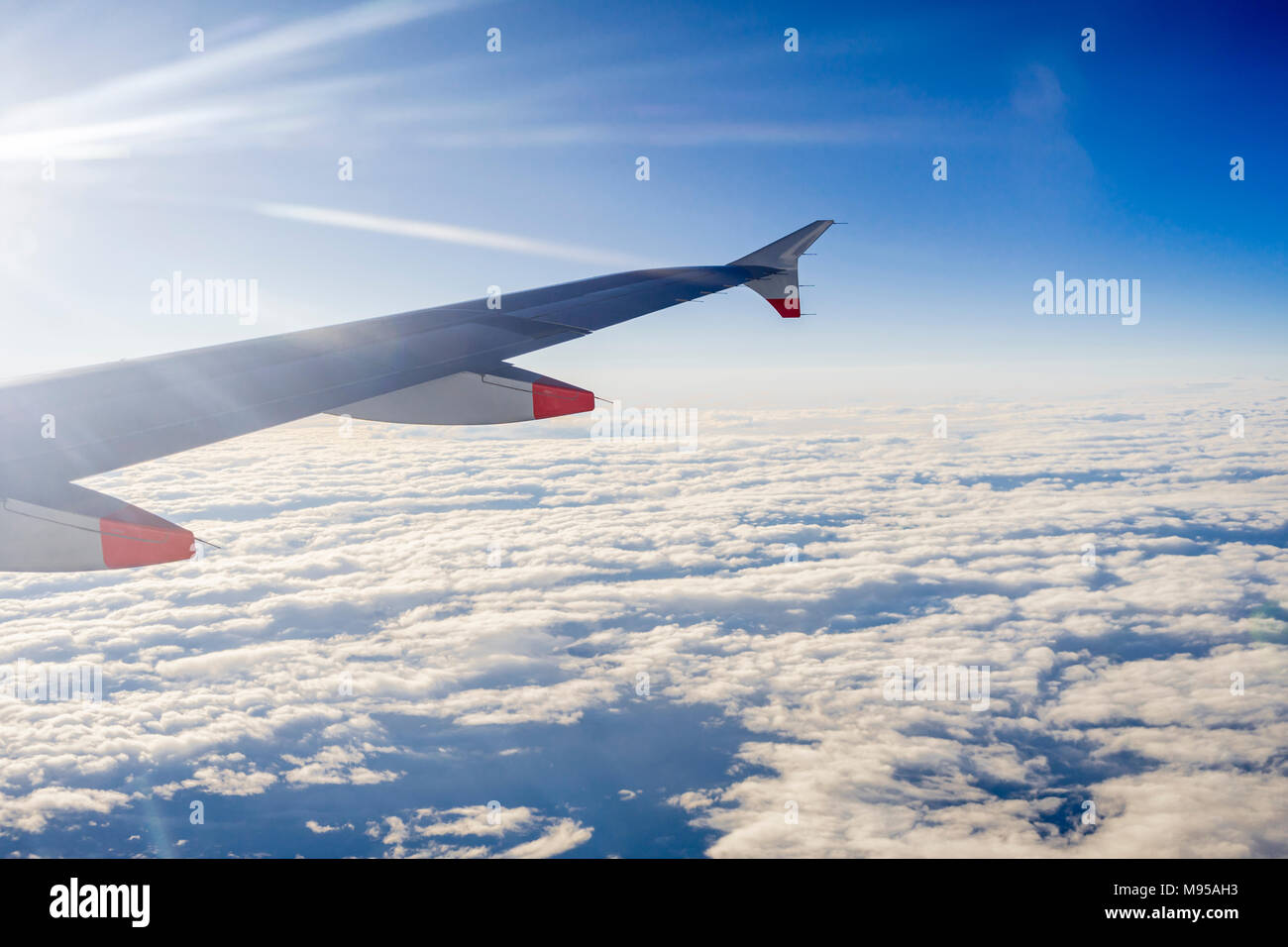 Vue depuis la fenêtre d'un avion en plein vol de l'aile d'avion avec ciel bleu et nuages stratocumulus visible Banque D'Images