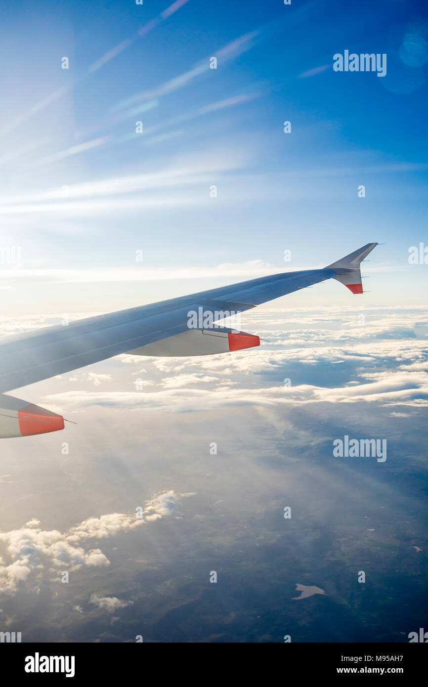 Vue depuis la fenêtre d'un avion en plein vol de l'aile d'avion avec ciel bleu et nuages stratocumulus visible Banque D'Images