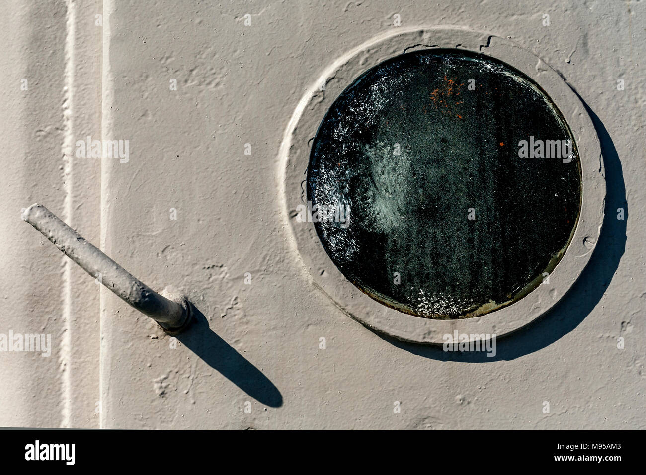 Nébuleuse sombre et verre trempé blanc hublot sur porte de ferry avec la poignée d'un après-midi à l'ombre et le hublot d'une ombre croissant Banque D'Images