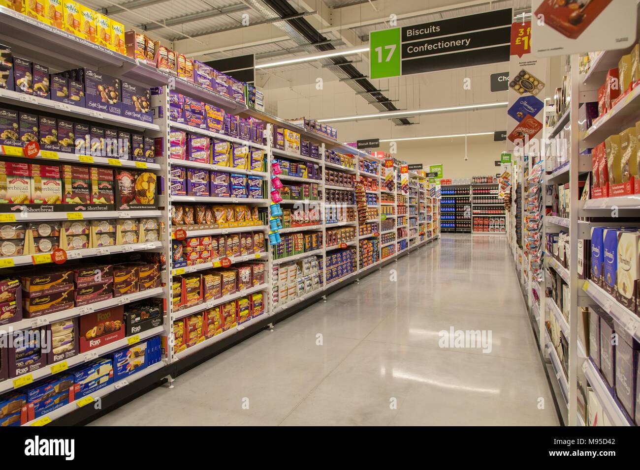 Biscuits et confiserie sur rayonnages remplis dans un supermarché Asda. Banque D'Images