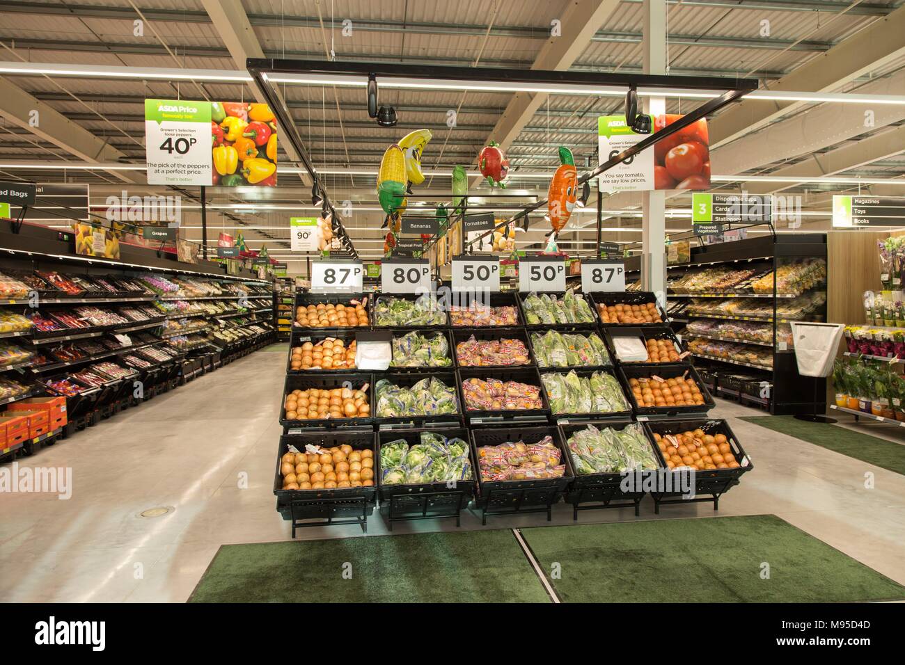 Les racks plein de fruits frais, de légumes, de produire dans un supermarché Asda. Banque D'Images