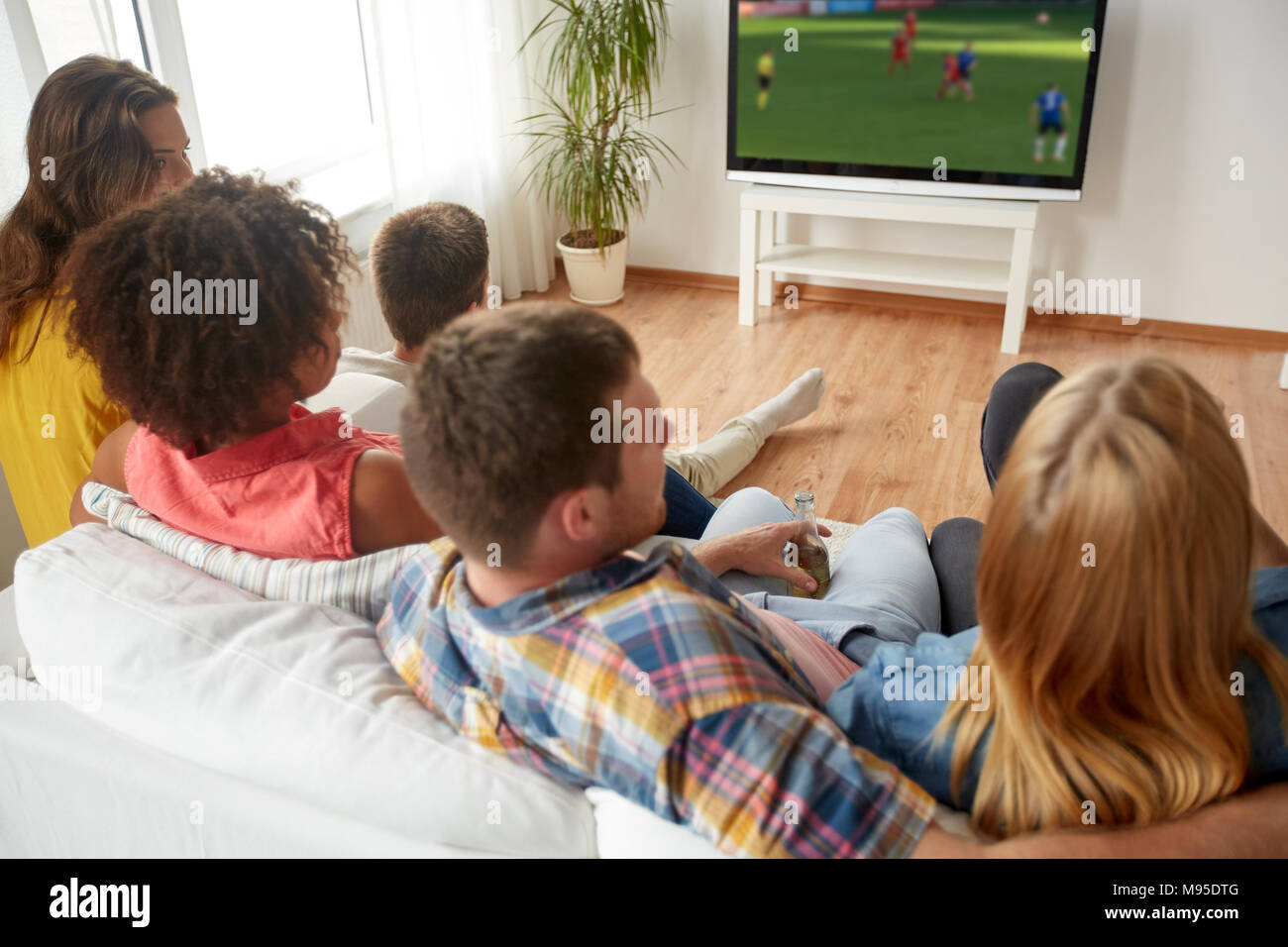 Les amis de regarder match de football à la télévision à la maison Banque D'Images