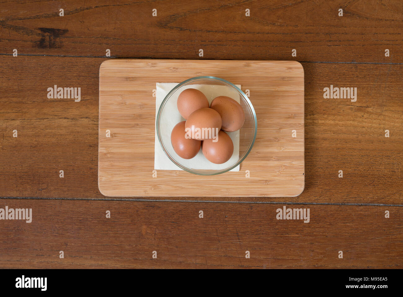 Quelques œufs dans un bol en verre sur une table en bois Banque D'Images