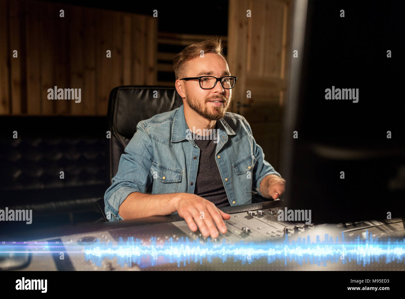 L'homme à une console de mixage en studio d'enregistrement musique Banque D'Images