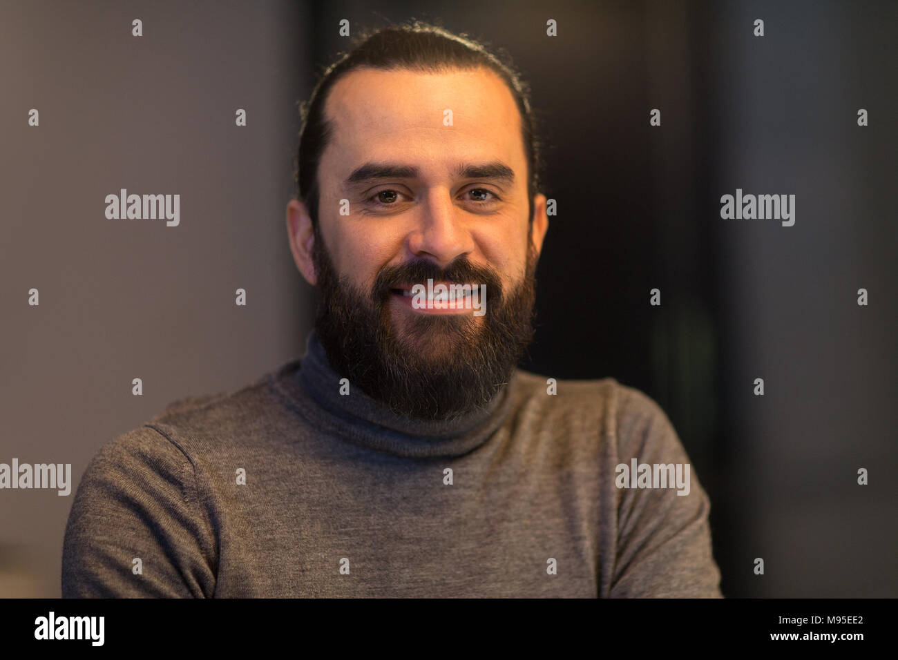 Smiling Middle Eastern man in polo col roulé Banque D'Images