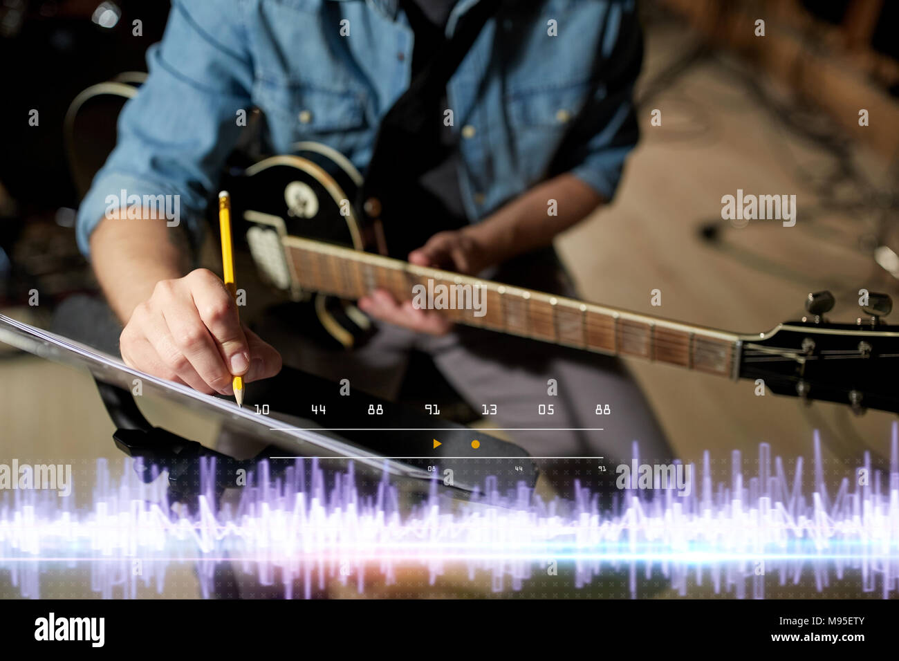 Musicien avec guitare et musique au studio Banque D'Images
