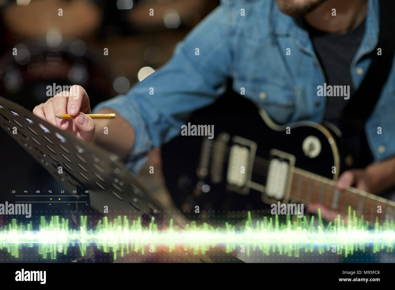 Musicien avec guitare et musique au studio Banque D'Images