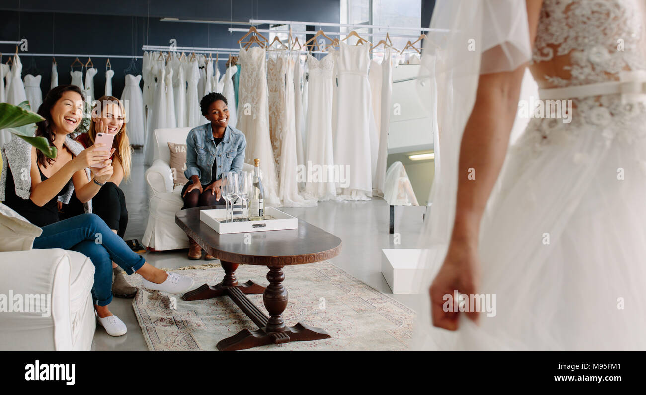 Heureuse mariée et demoiselles d'essayer sur des robes de mariage en beauté  Photo Stock - Alamy