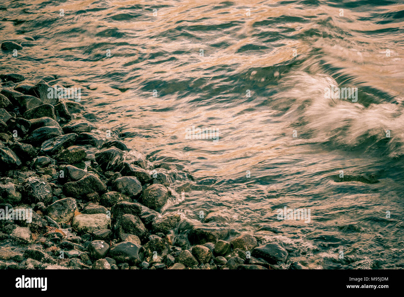 Un raz de marée sur la plage avec des cailloux gris Banque D'Images