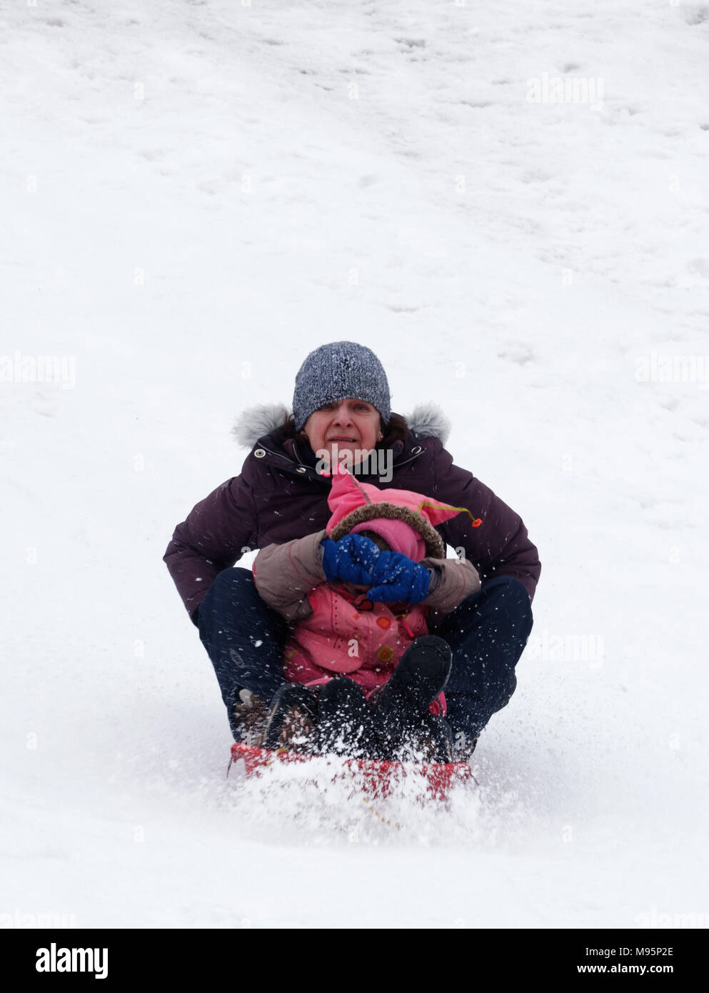 Grand-mère semble effrayé et petite-fille couvre ses yeux tandis que la luge au Québec, Canada Banque D'Images