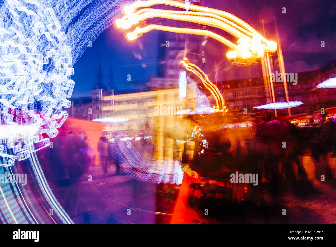 Madrid, Espagne : composition abstraite du marché de Noël sur la Plaza Mayor allumé au crépuscule. Banque D'Images