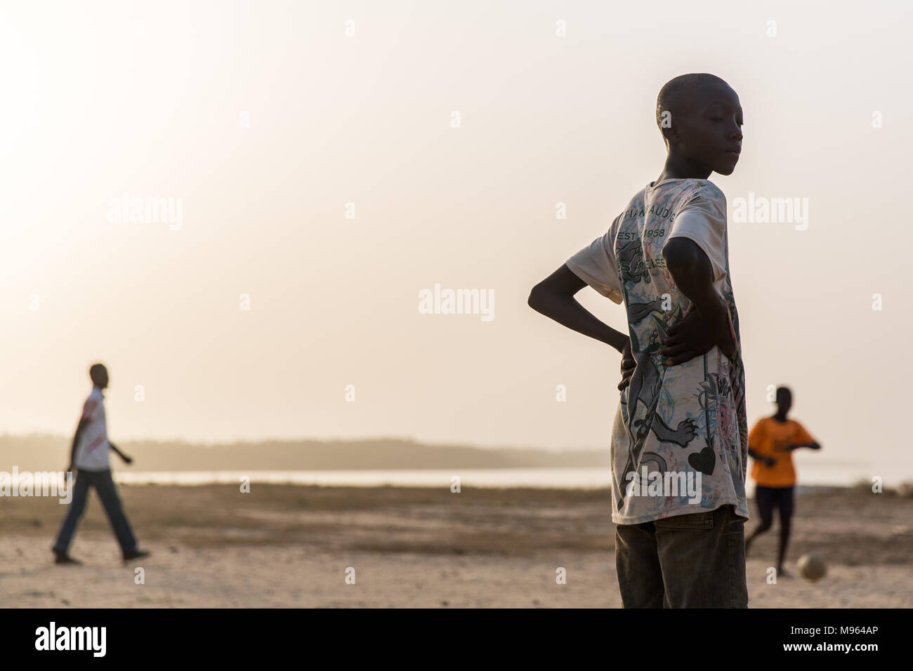 Un groupe de jeunes garçons jouent au football sur la rive de la rivière Gambie Tendaba dans. Banque D'Images