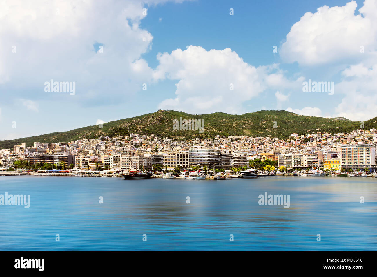 Kavala éclairée par le paysage urbain, l'une des plus grandes villes dans le nord de la Grèce, blur motion l'eau de mer et les nuages blancs au-dessus de la montagne Banque D'Images