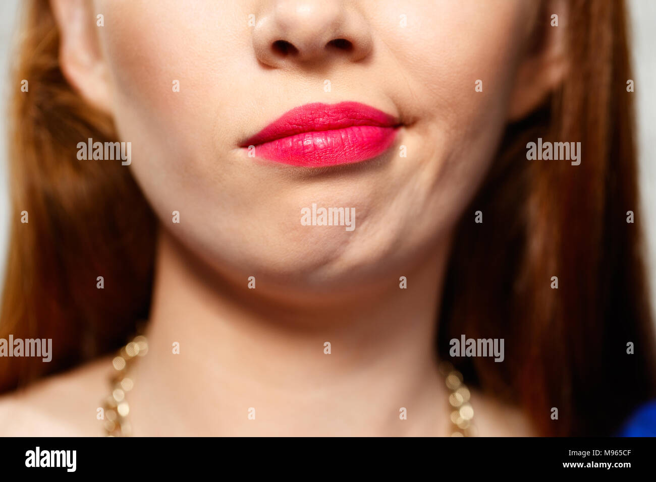 Portrait de femme l'insécurité ayant des doutes. Déplut redhead girl thinking, making a face. Close up de bouche Banque D'Images