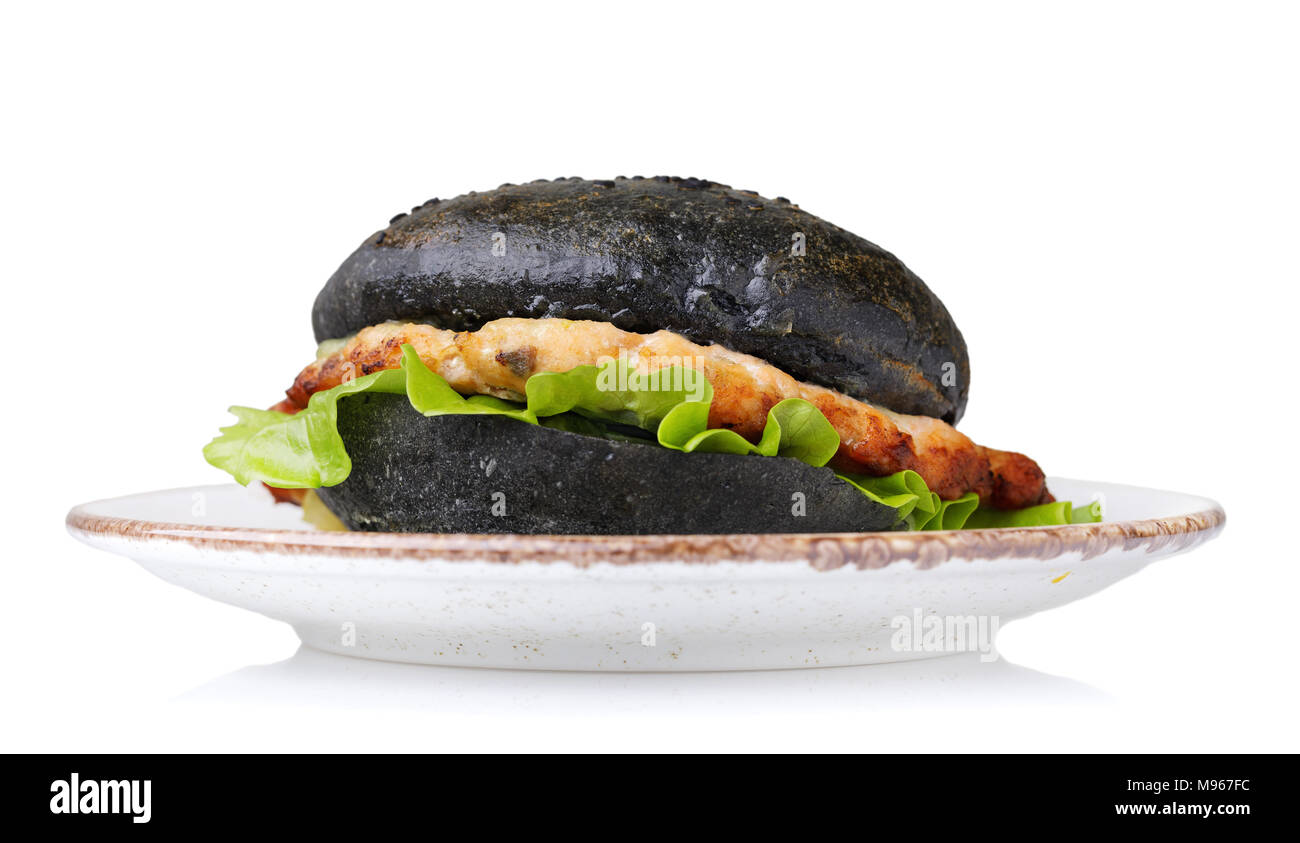 Hamburger fraîchement préparé avec le rouleau de couleur noire, les légumes et le saumon escalope. Sandwich Maison isolé sur fond blanc Banque D'Images
