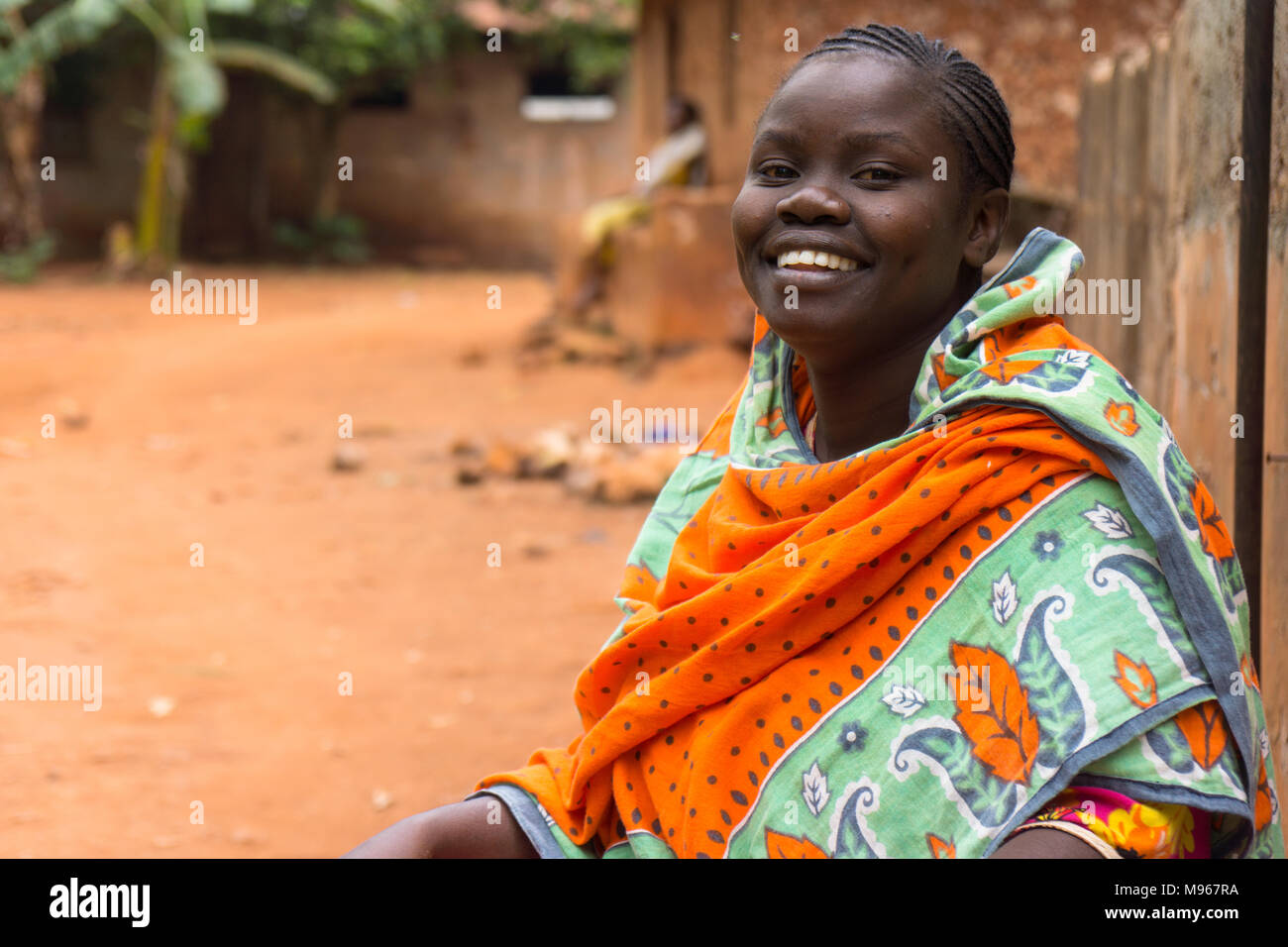 Smiling African woman travaillant dans sa cour d'entrée à Zanzibar, Tanzanie, Afrique de l'Est Banque D'Images