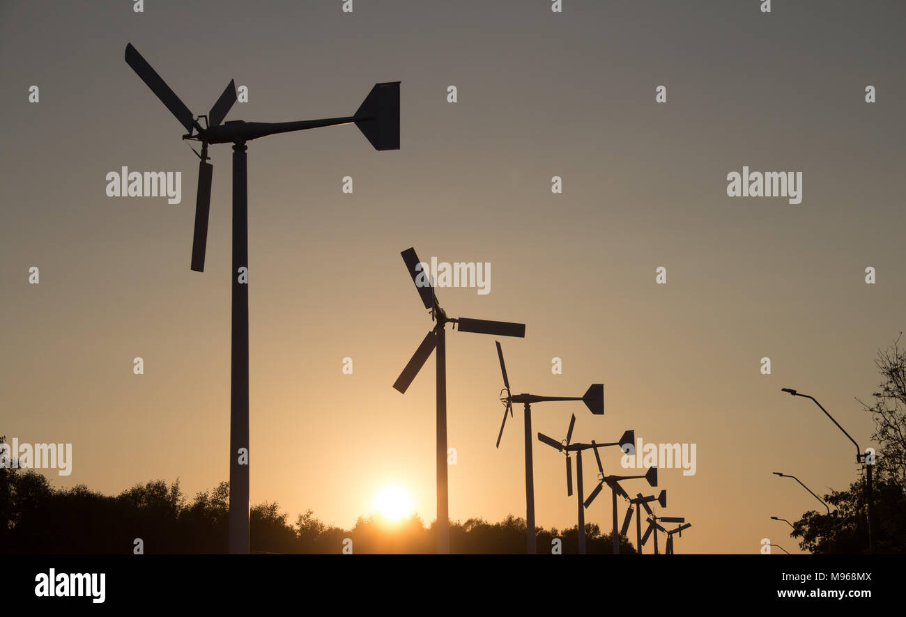 Les éoliennes produisant de l'électricité d'ossature avec coucher du soleil - Concept de conservation de l'énergie Banque D'Images