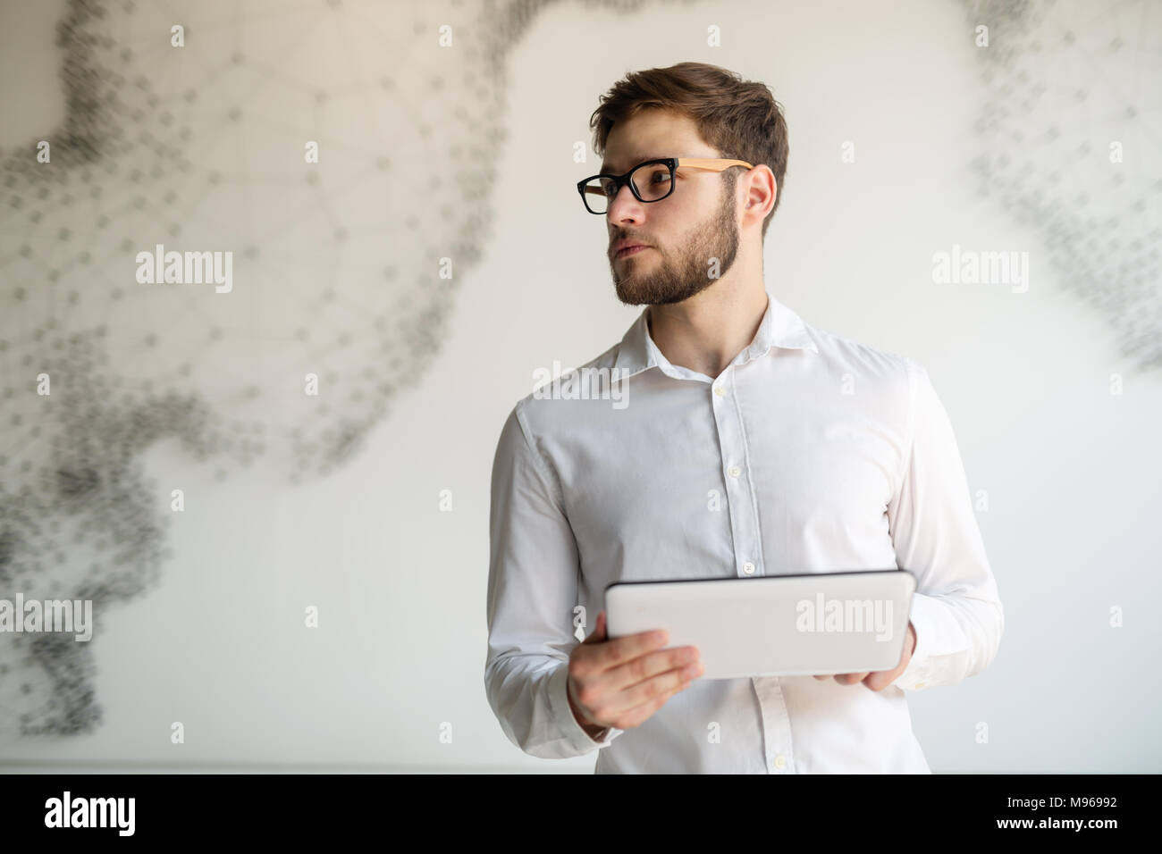 Businessman wearing glasses using tablet Banque D'Images