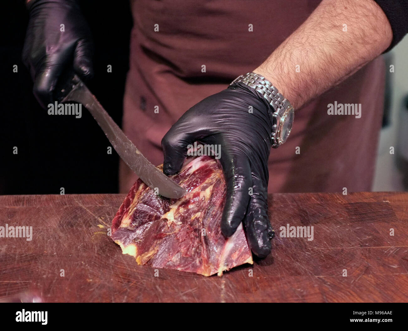 Les coupes d'un employé à un jamon jamon, stalle, jambon fumé espagnol décroche à la La Mercat de Sant Josep de la Boqueria, le centre de Barcelone, Espagne Banque D'Images