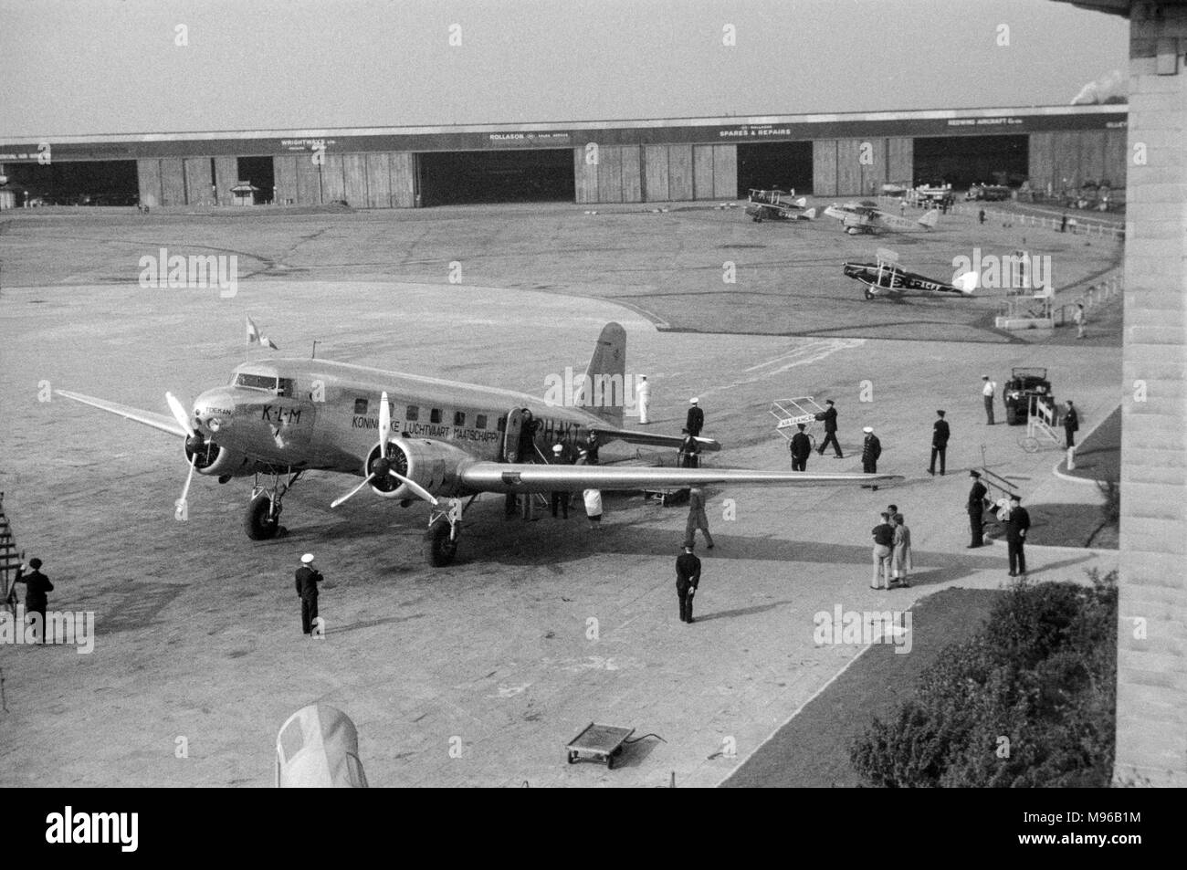 Un avion Douglas DC-2, PH-AKT, propriété de la compagnie aérienne néerlandaise KLM, à l'aéroport de Croydon près de Londres en 1936. beaucoup de petits aéronefs dans l'arrière-plan, y compris De Havilland Puss Moth G-ABHB, De Havilland Dragon G-ACIU, et de De Havilland Fox Moth G-ACFF. Des hangars et des ateliers sont visibles en arrière-plan. Banque D'Images