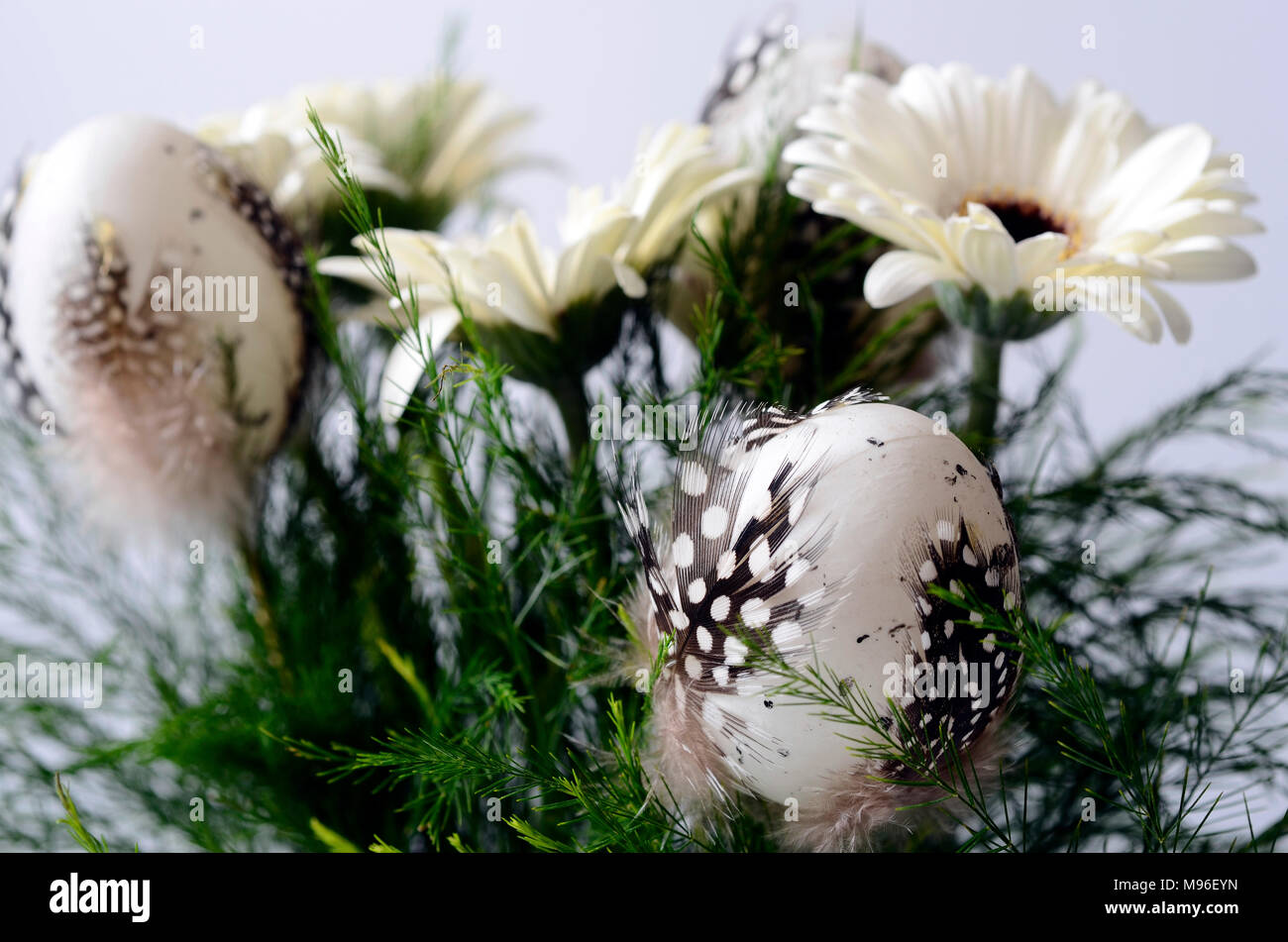 Jour de Pâques bouquet, fleurs blanches et d'oeufs de pâques avec des plumes d'oiseau Banque D'Images