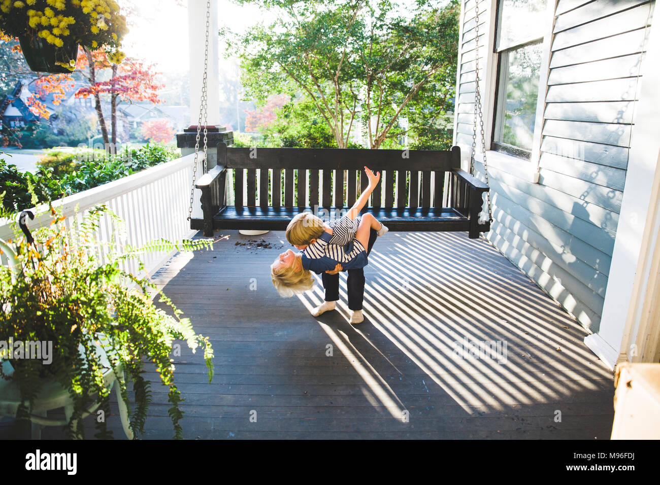 Enfants hugging on porch Banque D'Images