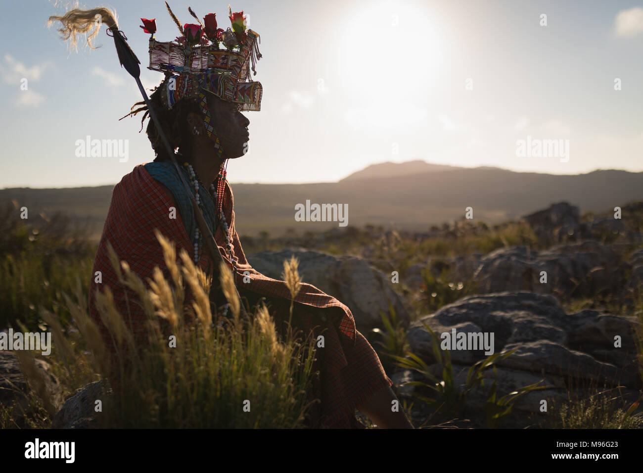 L'homme en costume traditionnel massaï assis à campagne Banque D'Images
